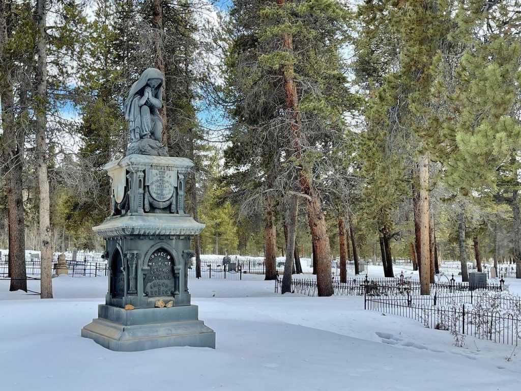 gravestone in winter with a blanket of snow on the ground.