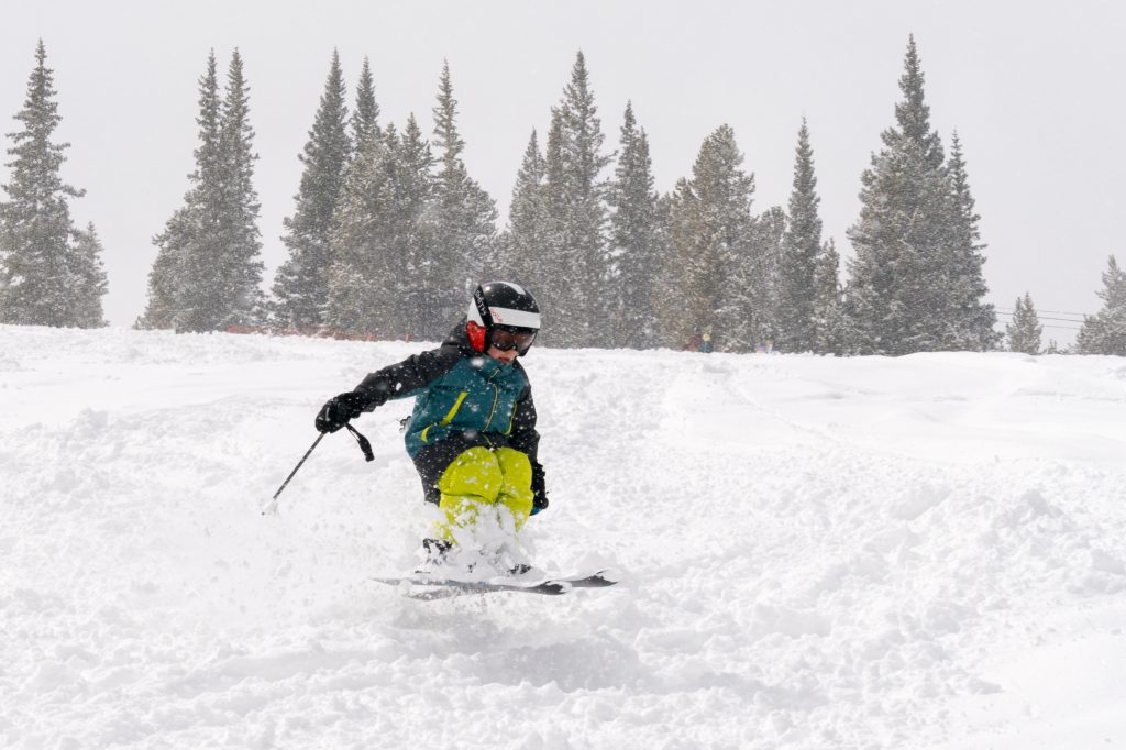kid skiing down a hill.