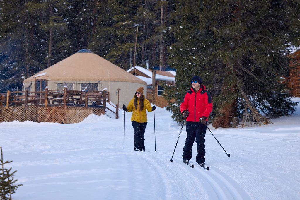 people skiing away from a yurt.