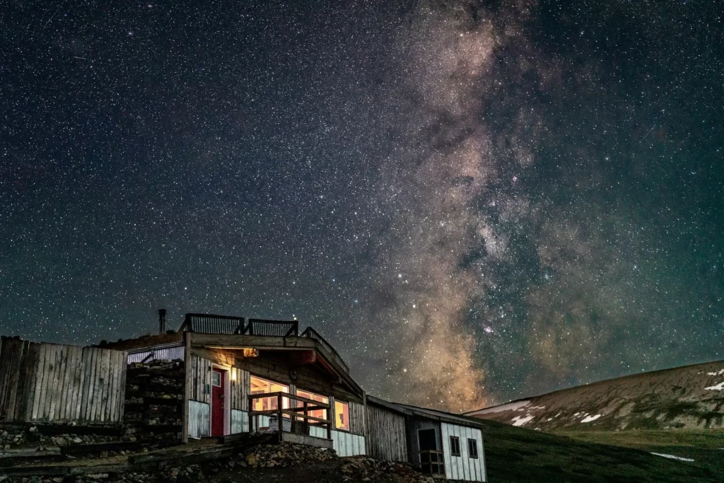Weston Pass Hut glowing at night under the stars near Leadville