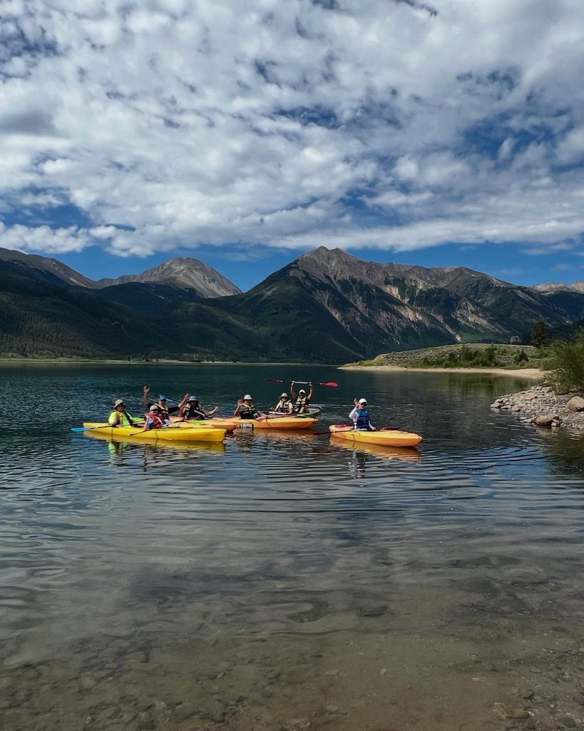 group of people kayaking on a lake.