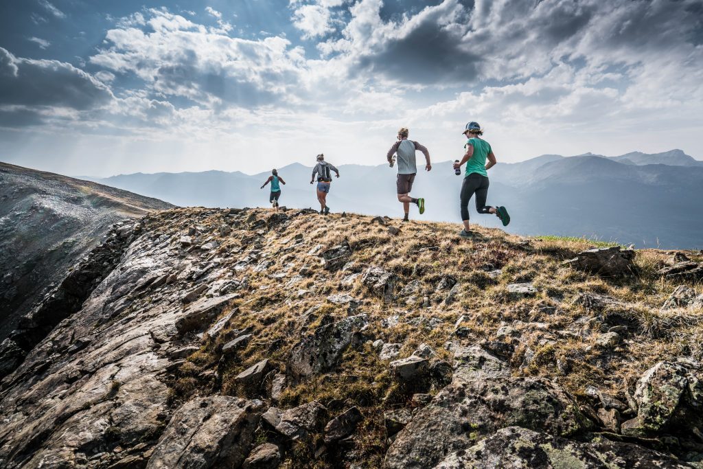 people running on top of a mountain.