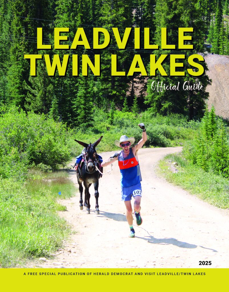 Magazine Cover yellow print title "Leadville Twin Lakes Official Guide" with a picture of a male running with a donkey along a dirt road