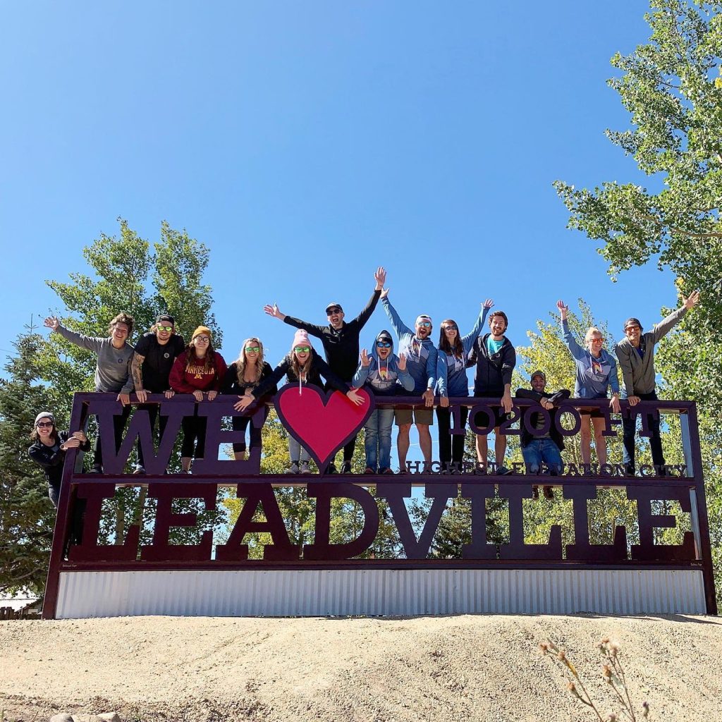 A group posing on the We Love Leadville Sign